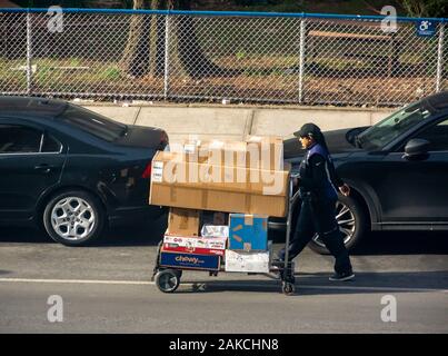 Un travailleur de FedEx avec sa charrette chargée de paquets dans le quartier de Chelsea, New York le Samedi, Décembre 28, 2019. (© Richard B. Levine) Banque D'Images