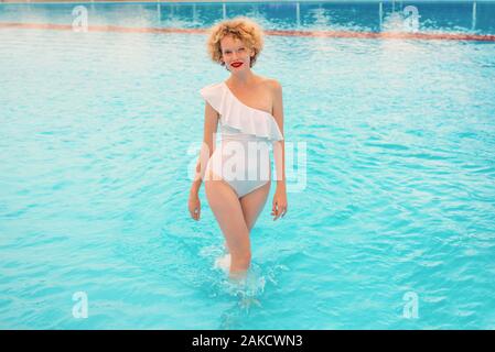 Beautiful smiling redhead woman portrait de profiter de la vie dans la piscine dans la journée d'été. L'été, vous détendre, bien-être, voyages, loisirs concept Banque D'Images