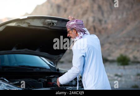 Fixation de l'homme arabes Senior sa voiture à l'extérieur Banque D'Images