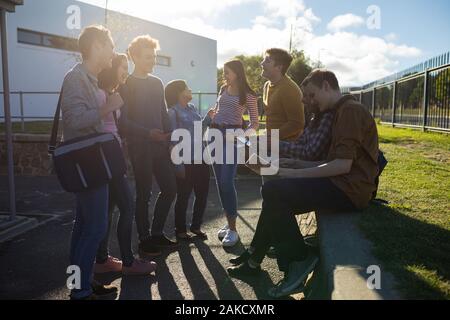 Les adolescents qui traînaient dans leur cour d'école Banque D'Images