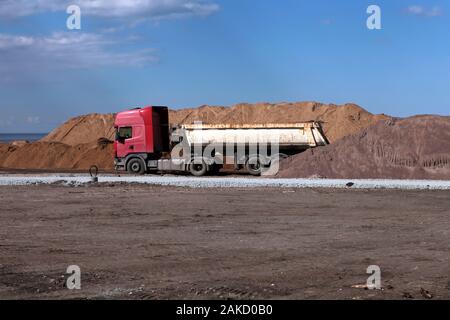 Vieux camion près de tas de sable à la construction de la route. roadworking site grand vieux concept construction benne Banque D'Images