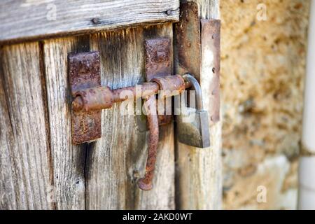 Image d'un boulon rouillé boor coulissante avec cadenas sur vieil porte. Banque D'Images