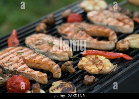 Darnes de saumon grillés avec des légumes sur le grill Banque D'Images