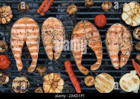 Darnes de saumon grillés avec des légumes sur le grill Banque D'Images