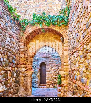 Puerta de Los Cuartos de Granada ou les salles de Grenade Gate avec col étroit, entouré de grands murs médiévaux de forteresse Alcazaba, Malaga, Espagne Banque D'Images