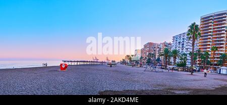 MALAGA, ESPAGNE - 26 septembre 2019 : le coucher du soleil panorama de la plage de Malagueta de sable avec la ligne de maisons, hôtels, cafés et magasins touristiques, sur Banque D'Images