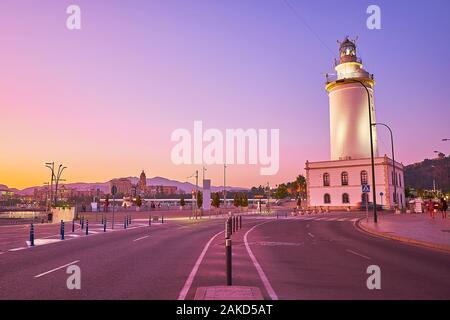 La Farola, promenade à pied et profiter de la vue le soir de Malaga phare (faro), situé à l'entrée du port, Espagne Banque D'Images