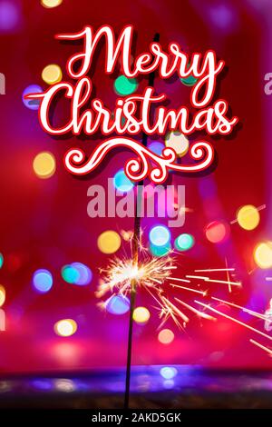 Joyeux noël.gravure scintillant sparkler sur rouge et la couleur d'arrière-plan bukeh Banque D'Images