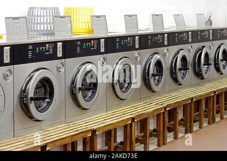 Une rangée de machines à laver industrielles dans une boutique de linge Banque D'Images