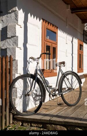 Vieux vélo appuyé contre le mur d'une Maisons en bois sur le marché en galicien musée en plein air, Pologne Banque D'Images