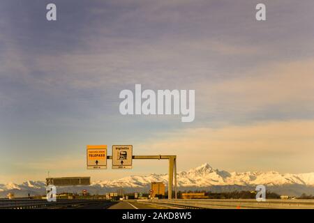 Vue panoramique sur les Alpes italiennes avec Monviso peak (3841 m.) de l'autoroute A6 Turin-Savona avec panneaux de sortie d'une journée d'hiver ensoleillée, Piémont, Italie Banque D'Images