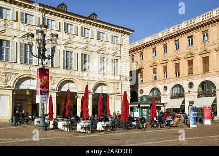 Aperçu de la Piazza San Carlo, dans le centre de Turin avec les gens profiter du soleil dans un café-terrasse le jour avant Noël, Piémont, Italie Banque D'Images