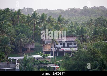 Grande maison avec balcon extérieur niché dans la jungle tropicale Banque D'Images