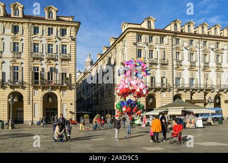 Aperçu de la Piazza Castello, dans le centre de Turin avec un vendeur de ballons, les personnes et les familles dans une journée ensoleillée avant Noël, Piémont, Italie Banque D'Images