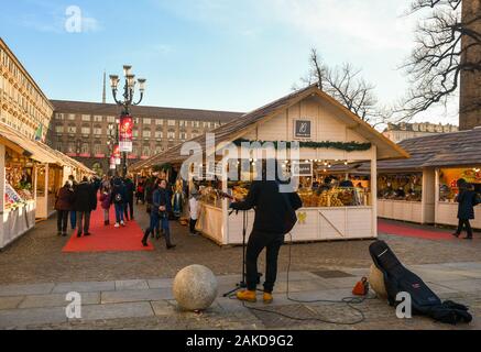 Le marché de Noël à la Piazza Castello, dans le centre de Turin avec un musicien de rue et les gens des magasins la veille de Noël, le Piémont, Turin Banque D'Images