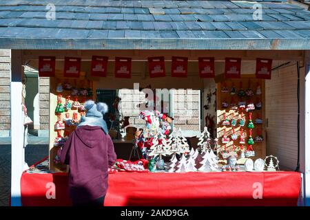 Un vendeur d'organiser son stand de la rue d''objets artisanaux au marché de Noël de la Piazza Castello, dans le centre de Turin, Piémont, Italie Banque D'Images