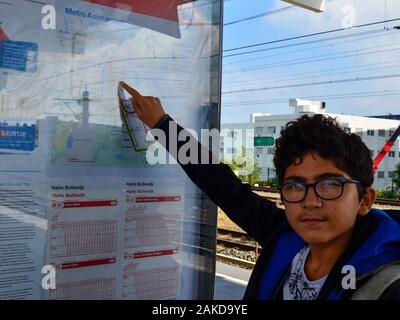 Amsterdam, Pays-Bas, août 2019. Un brown-haired woman with glasses points à un point sur le plan du métro. Banque D'Images