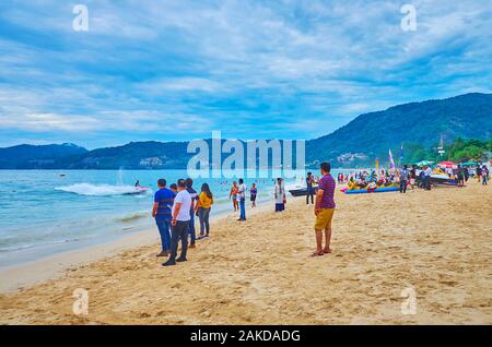 PATONG, THAÏLANDE - Mai 1, 2019 : les vacanciers se détendre et marcher le long de la plage, agréable à regarder fast riding scooter, le 1 mai à Patong Banque D'Images