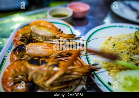 Bangkok/Thailand-December2019:les crevettes grillées sur une plaque avec du riz frit sur une plaque et les sauces en arrière-plan sur une table de nuit dans le quartier chinois Banque D'Images