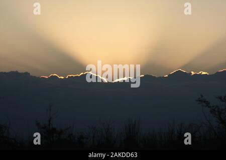 Rayons du soleil émergeant de derrière une masse de nuages Banque D'Images