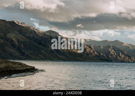 Le soleil graud les montagnes accidentées et la plage sur le lac Hawea, Nouvelle-Zélande Banque D'Images