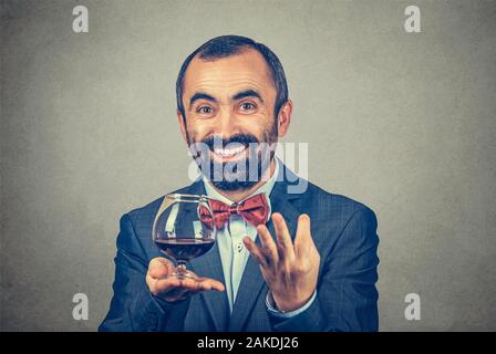 Smiling man wearing italien barbus adultes veste élégante avec nœud Papillon rouge avec un verre de vin à la demande à huis clos que dites-vous avec geste de la main je Banque D'Images