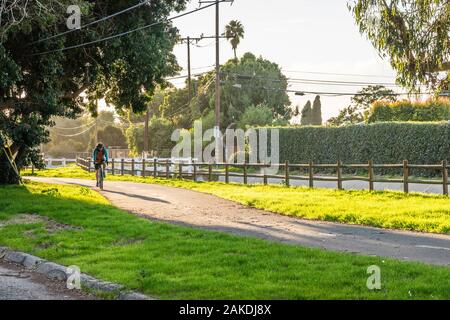 Une piste cyclable très utilisé en fin d'après-midi avec une lumière dramatique bike rider homme à cheval sur le chemin. Banque D'Images