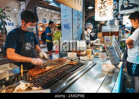 Un homme braise et hache des champignons d'huîtres en morceaux au Shi Lin Night Market, Taipei, Taïwan Banque D'Images