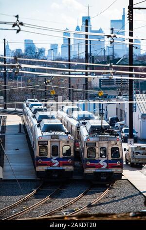 Image de deux septa en stationnement sur les voies de train avant d'un la Philadelphia skyline. Banque D'Images