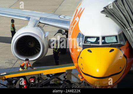 Bangkok, Thaïlande - le 5 décembre 2019 : les travailleurs de l'équipe au sol d'aéronefs contrôle moteur turbine, d'admission d'air et de la courroie du convoyeur de sac Nok Air avant de l'avion Banque D'Images