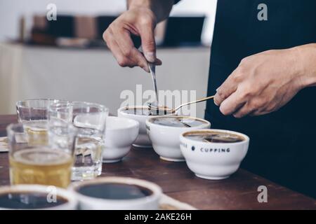 Niveleuse professionnel Q préparation à l'essai et l'inspection de la qualité du café et de l'écrémage de café à partir de la tasse en céramique sur la table. Banque D'Images