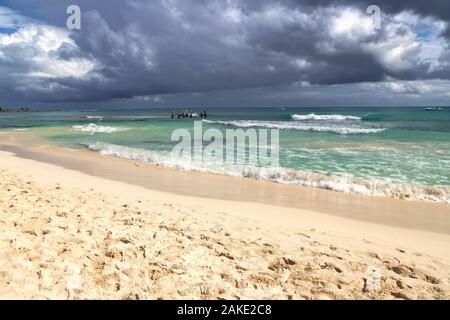 De sombres nuages se forment au-dessus de la mer avec des vagues se brisant la plage que les approches. Banque D'Images