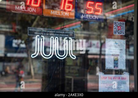 E-cigarette Juul vaping en néon avec avertissement de la nicotine posté à l'extérieur de liquor store Banque D'Images