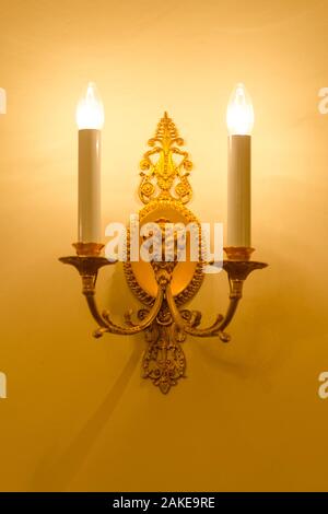 Mur lumière de métal doré avec deux des bougies électriques Banque D'Images