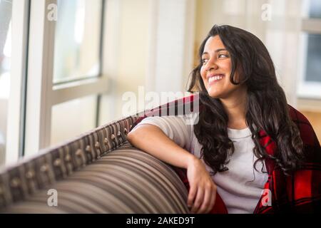 Portrait of a young woman enveloppé dans une couverture chaude. Banque D'Images