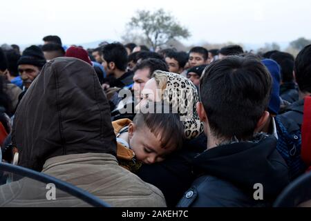 Une femme syrienne tient son fils en tant que réfugiés attendent de passer la frontière de la Macédoine grecque à l'intérieur du camp de réfugiés de fortune d'Idomeni dans le nord de la Grèce. Banque D'Images