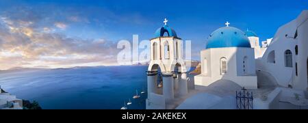 Soleil panoramique sur l'église orthodoxe grecque de l'Oia (Ia), Cyclades île de Thira, Santorin, Grèce. Le règlement d'Oia a être Banque D'Images