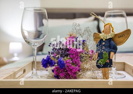 Décoration de la vie encore deux verres de vin vide, un home-made rag angel toy et bouquet de fleurs séchées. Banque D'Images