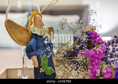 Décoration de la vie encore deux verres de vin vide, un home-made rag angel toy et bouquet de fleurs séchées. Banque D'Images