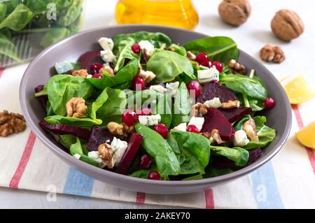 Avec de jeunes épinards, salade de betteraves cuites, fromages bleus, les noix, les canneberges dans un bol sur un fond clair. Régime alimentaire savoureux plat de remise en forme. La vitamine salade. Bon Banque D'Images