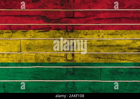 Drapeau national de Bolivie sur un mur en bois, arrière-plan. La notion de fierté nationale et un symbole du pays. Drapeaux peints sur une clôture en bois avec Banque D'Images