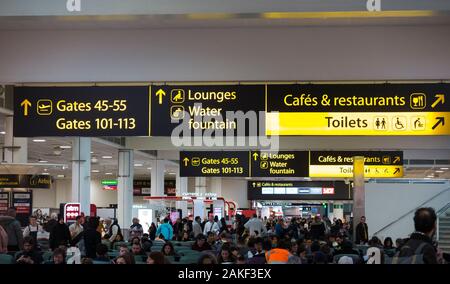 Panneau / signalisation sur le plafond du salon de départ de l'aéroport du terminal nord de Gatwick, y compris les portes et les numéros de portes / toilettes / toilettes / toilettes / toilettes / toilettes sanitaires et au café et restaurant à l'étage. Londres (115) Banque D'Images