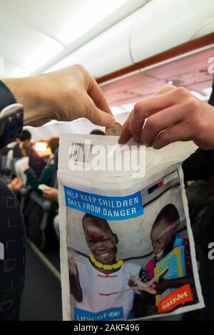 Un sac de collecte de dons caritatifs de l'UNICEF est retiré par un membre de l'équipage de cabine du Royaume-Uni d'un avion d'avion pour recueillir un petit argent et argent en espèces auprès des passagers. L'argent recueilli sera dans la lutte contre la poliomyélite. ROYAUME-UNI (115) Banque D'Images