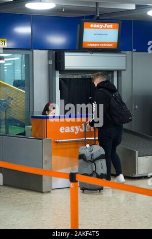 Les passagers d'Easyjet pour 24 passagers de vérifier dans leur cas spéciaux ou plus de bagages surdimensionnés, taille, valises / valise costume. L'aéroport, la Suisse. (115) Banque D'Images