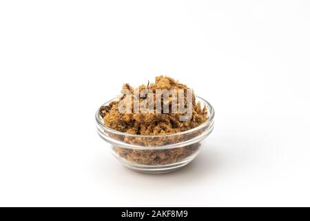 Porc frit salée intérieure duvan cvarci, Greaves, dans un bol en verre sur un fond blanc Banque D'Images