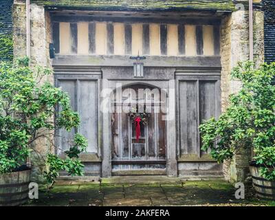 Une porte à une grande maison dans le village de Cotswold Hampnet dans le Gloucestershire. Banque D'Images