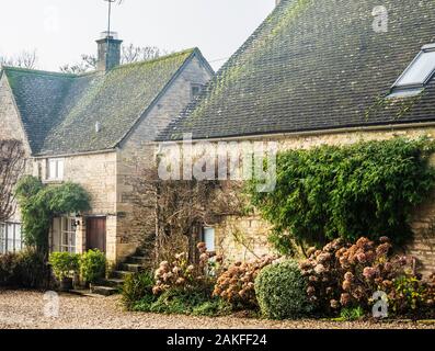 Quelques jolies maisons en pierre dans le village de Cotswold Hampnet dans le Gloucestershire. Banque D'Images