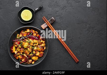 Kung Pao Paneer à fond en ardoise noire. Kung Pao Paneer est une version végétarienne de plat chinois Sichuan Gong Bao avec paneer fromage, arachides, chill Banque D'Images