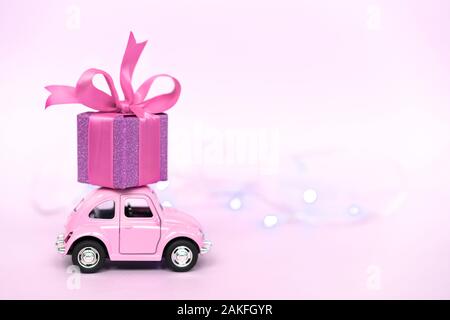 Sotchi, Russie - 8 janvier 2020 : petite voiture rétro Rose boîte cadeau offrir pour la Saint-Valentin sur fond rose. 14 février, 8 mars, Journée internationale de la femme heureuse. Banque D'Images