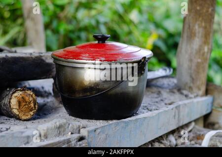 Pot avec couvercle rouge rustique prêt à cuire. Banque D'Images